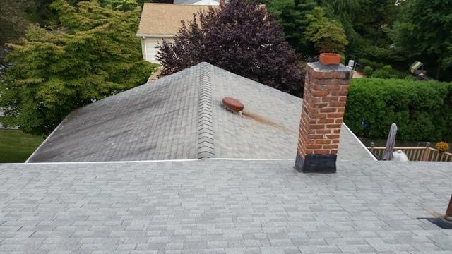 Existing shingle roof with chimney before roofing work